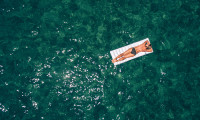 Woman floating on airbed in the sea, hr