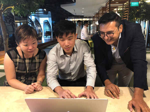 Foo Cher Fong (middle), a data scientist who joined DBS through last year’s Hack2Hire programme, working with DBS colleagues.